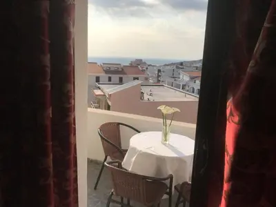 a table with a vase of flowers on a balcony at Apartments Radosevic in Ulcinj
