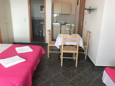 a room with a table and chairs and a kitchen at Apartments Radosevic in Ulcinj