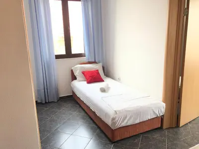 a small bed in a room with a window at Apartments Radosevic in Ulcinj