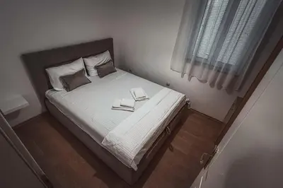 a bedroom with a bed with two books on it at Apartment Podgorica Center in Podgorica