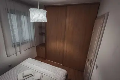 a small room with a bed and a mirror at Apartment Podgorica Center in Podgorica