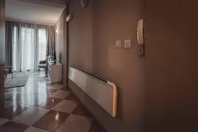 a hallway with a wall with a rail in a room at Apartment Podgorica Center in Podgorica