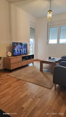 a living room with a flat screen tv and a table at Vincent Van Gogh in Podgorica