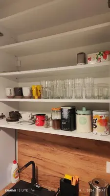 a kitchen shelf with glasses and dishes on it at Vincent Van Gogh in Podgorica
