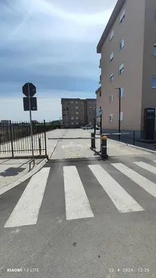 an empty street with a crosswalk in front of a building at Vincent Van Gogh in Podgorica
