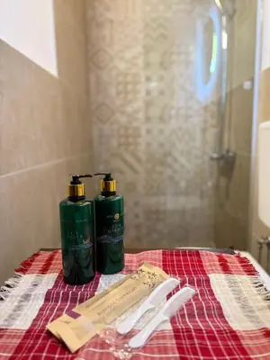two green bottles sitting on top of a towel at Shasi Eco Lodge in Ambula