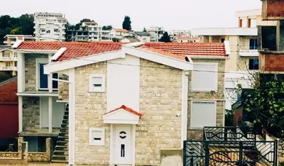 a brick house with a white door in a city at Vila Kajevic in Ulcinj