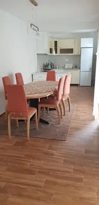 a dining room with a table and chairs and a kitchen at Vila Kajevic in Ulcinj