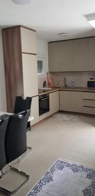 a kitchen with a table and chairs in a room at Vila Kajevic in Ulcinj