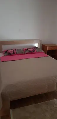 a white bed with two pillows on top of it at Vila Kajevic in Ulcinj