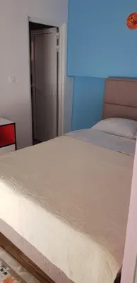 a bed in a bedroom with a blue wall at Vila Kajevic in Ulcinj