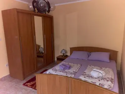 a bedroom with a bed with a cabinet and a mirror at Квартира 200м от моря. in Bar