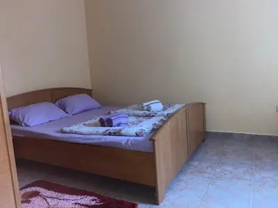a bedroom with a wooden bed with purple pillows at Квартира 200м от моря. in Bar