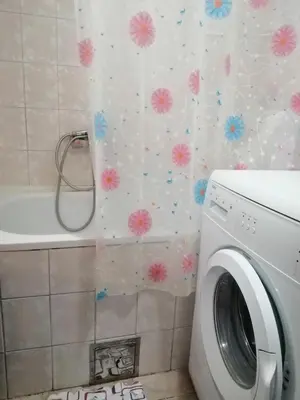 a washing machine in a bathroom with flowers on the wall at Квартира 200м от моря. in Bar