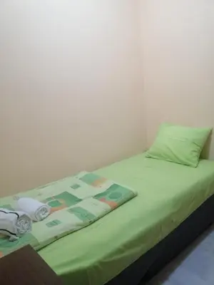 a bed with a green comforter and towels on it at Квартира 200м от моря. in Bar
