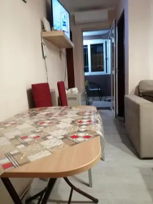 a table and chairs in a living room with a couch at Квартира 200м от моря. in Bar