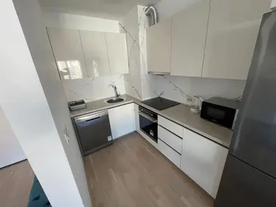 a small kitchen with white cabinets and a sink at Lux apartment Komel in Budva