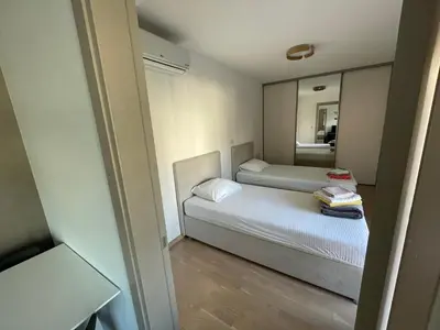 a small bedroom with two beds and a mirror at Lux apartment Komel in Budva