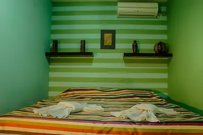 a bedroom with a bed with green striped walls at Villa Danile Cosy Apartments in Budva