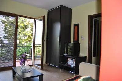 a living room with a tv and a black cabinet at Villa Danile Cosy Apartments in Budva