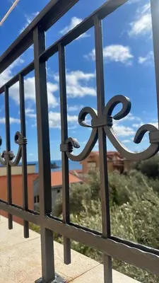 a metal fence with a view of the ocean at Apartments Ivan in Petrovac na Moru