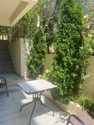a patio with a table and some bushes at Apartments Ivan in Petrovac na Moru
