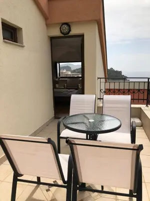 a patio with a table and chairs on a balcony at Apartments Ivan in Petrovac na Moru