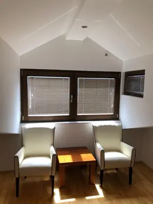 two chairs and a table in a room with windows at Apartments Ivan in Petrovac na Moru