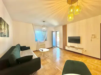 a living room with a couch and a tv at Comfort Family Apartment Eva in Budva