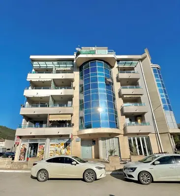 two cars parked in front of a building at Comfort Family Apartment Eva in Budva