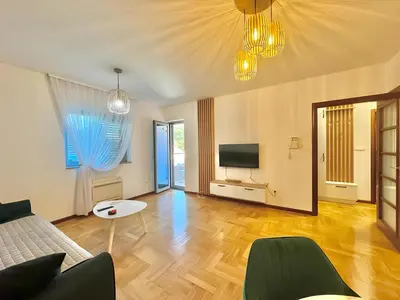 a living room with a couch and a tv at Comfort Family Apartment Eva in Budva