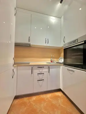 a white kitchen with white cabinets and a microwave at Comfort Family Apartment Eva in Budva