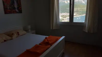 a bedroom with a bed and a large window at Apartments Spas in Budva