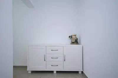 a white dresser against a white wall at Apartments Spas in Budva