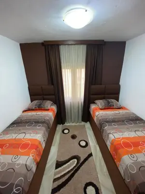 two beds in a small room with a window at Apartment Jovicevic in Rijeka Crnojevića