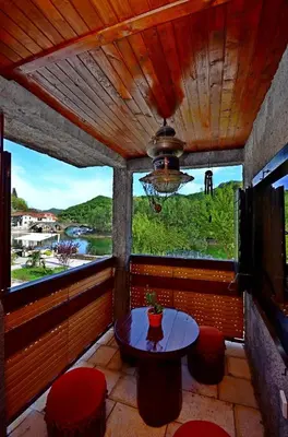 a room with a table and a large window at Apartment Jovicevic in Rijeka Crnojevića