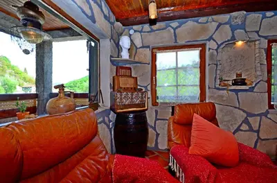 a living room with a couch and a stone wall at Apartment Jovicevic in Rijeka Crnojevića