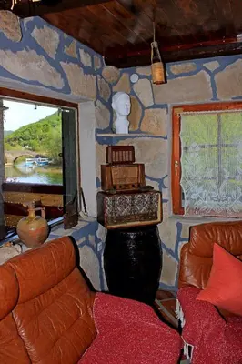 a living room with a couch and a stone wall at Apartment Jovicevic in Rijeka Crnojevića