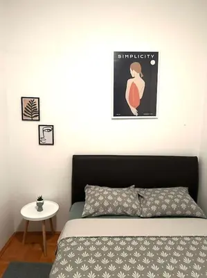 a bedroom with a bed and a small table at Cozy, charming one bedroom apt in Podgorica