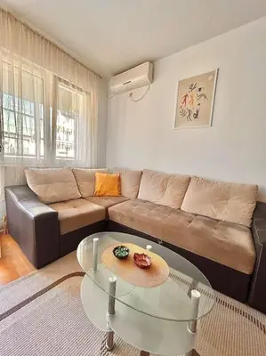 a living room with a couch and a glass table at Cozy, charming one bedroom apt in Podgorica