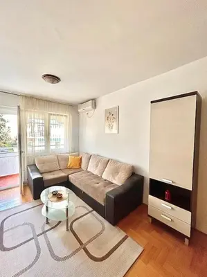 a living room with a couch and a table at Cozy, charming one bedroom apt in Podgorica