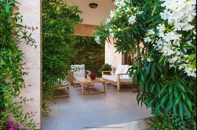 a patio with white flowers and a table and chairs at Wall Villa in Bar