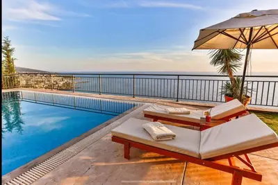a villa with a swimming pool and an umbrella at Wall Villa in Bar