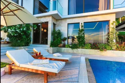 a house with two lounge chairs and a swimming pool at Wall Villa in Bar