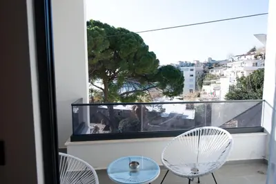 a balcony with two chairs and a table and a window at Botanica Boutique Hotel in Ulcinj