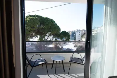 a balcony with chairs and a table and a window at Botanica Boutique Hotel in Ulcinj