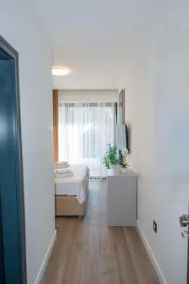 a white bedroom with a bed and a window at Botanica Boutique Hotel in Ulcinj