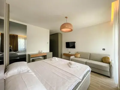a bedroom with a large bed and a couch at Botanica Boutique Hotel in Ulcinj