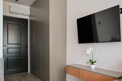 a hallway with a door and a television on a wall at Botanica Boutique Hotel in Ulcinj