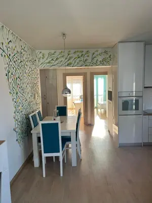 a kitchen and dining room with a table and chairs at Ana’s 2 bedrooms lovely flat in Podgorica